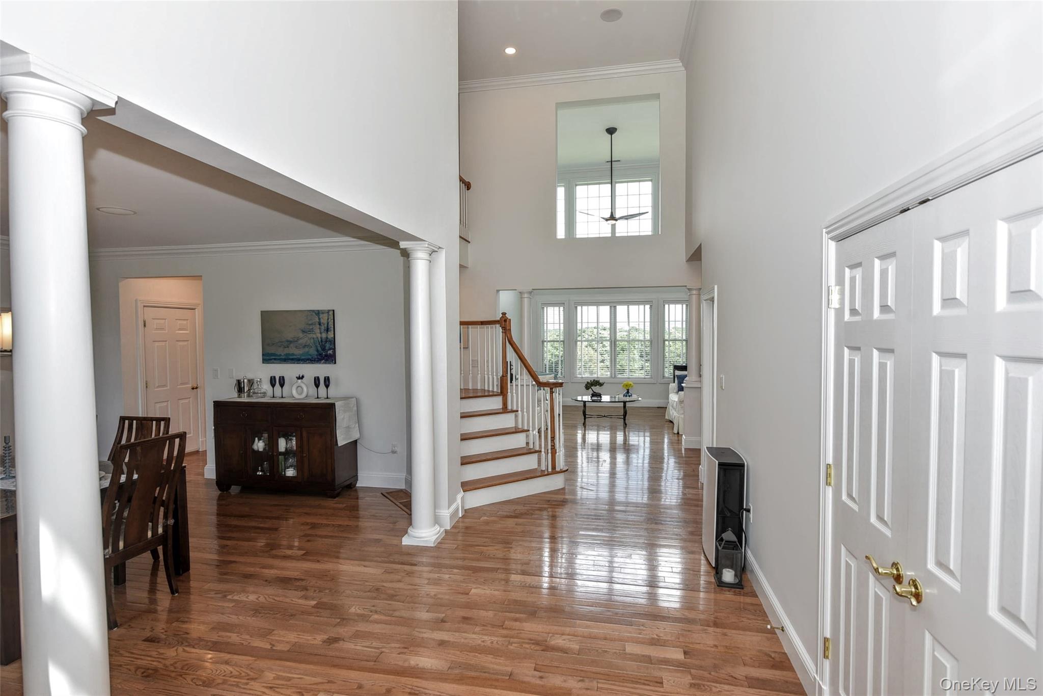 46 Mansion Ridge Boulevard Monroe, NY 10950 - Photo 6 of 46 Two-story foyer featuring wood-finish flooring, a grand staircase with white risers and wood treads, and architectural columns