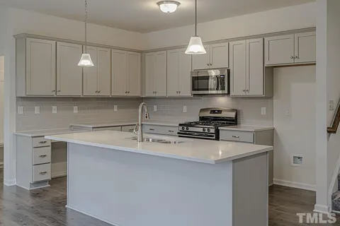 a kitchen with stainless steel appliances granite countertop a sink a stove and a refrigerator