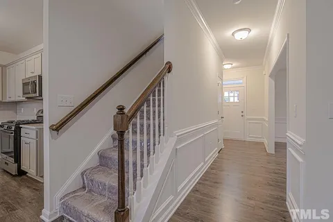 a view of hallway with stairs and wooden floor