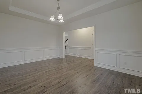 wooden floor in an empty room with a chandelier
