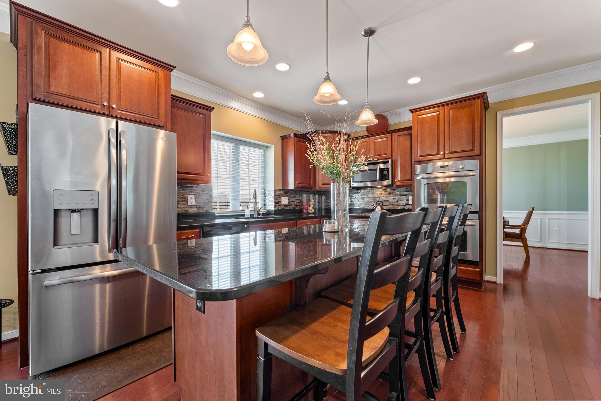 16 Barley Mill Court Stafford, VA 22554 - Photo 10 of 48 a kitchen with stainless steel appliances granite countertop a refrigerator a oven a kitchen island a stove and a refrigerator with wooden floor