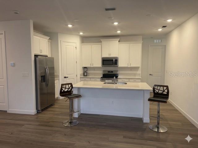 3495 Harborside Avenue Fort Pierce, FL 34946 - Photo 5 of 15 a kitchen with kitchen island a counter top space a sink appliances and cabinets