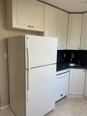 a white refrigerator freezer and cabinets