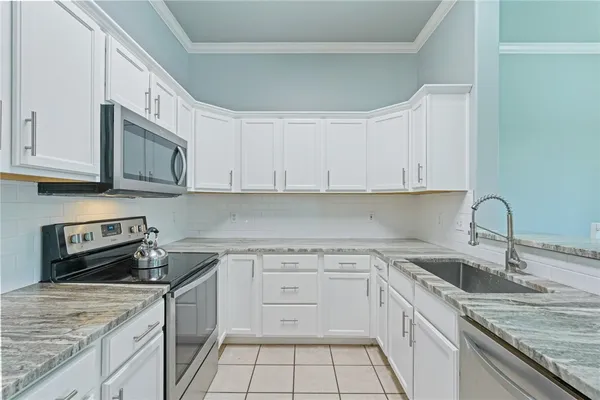 a kitchen with stainless steel appliances granite countertop a sink stove and cabinets