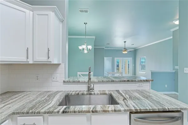 a kitchen with granite countertop a sink and a stove