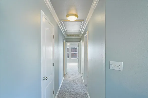 a view of a hallway with wooden floor and a chandelier