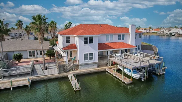 a small pool with lawn chairs under an umbrella