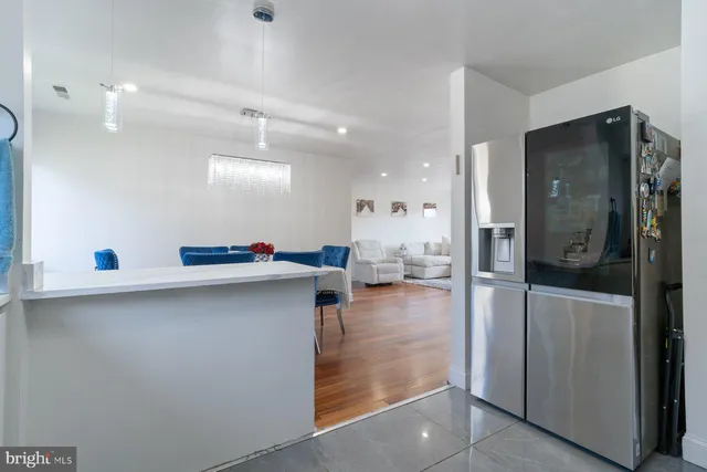 a open kitchen with stainless steel appliances a refrigerator and a table