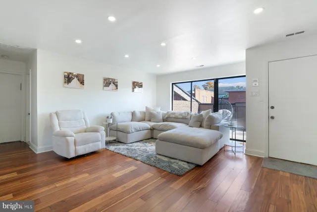 a living room with furniture and a wooden floor