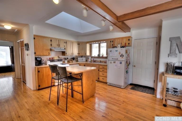 1047 Lakeview Road Copake, NY 12516 - Photo 8 of 10 a kitchen with stainless steel appliances a refrigerator a stove a sink dishwasher and a dining table with wooden floor