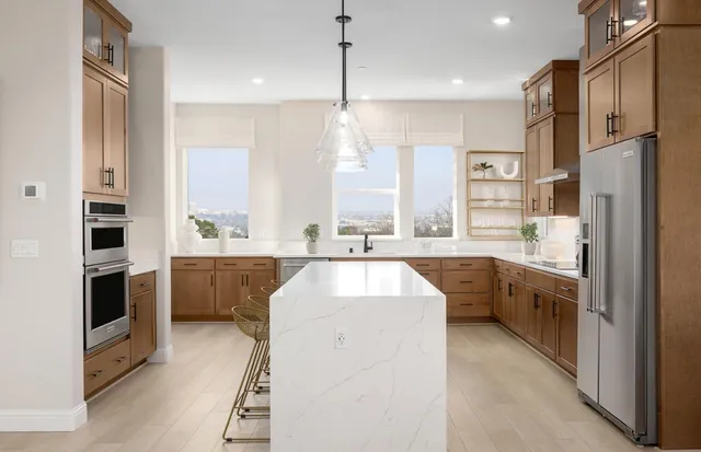 a large kitchen with kitchen island white cabinets stainless steel appliances and a center island