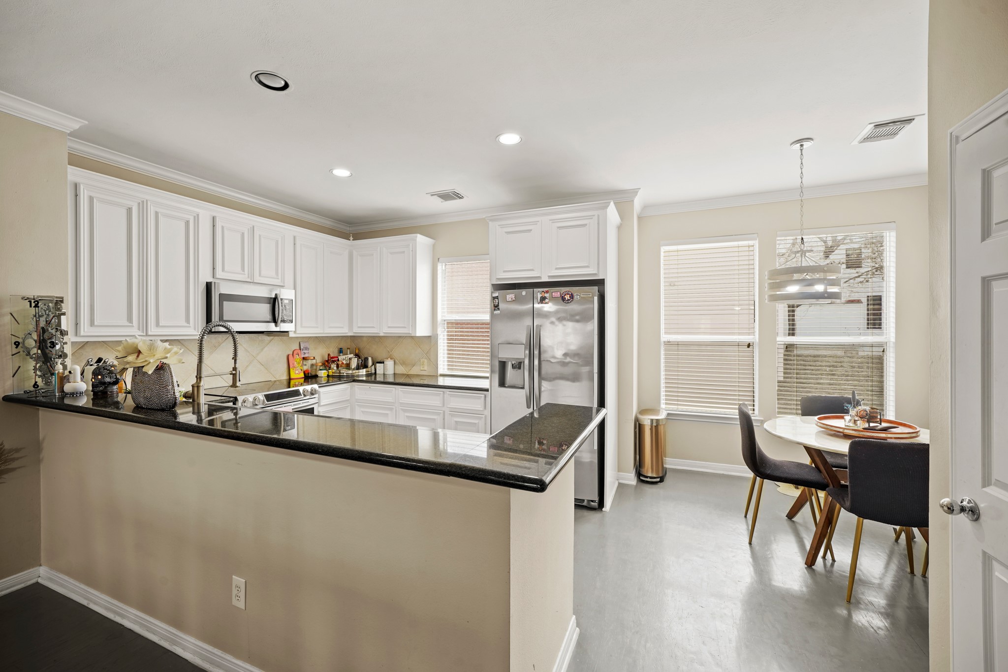 2605 West Dallas Street Houston, TX 77019 - Photo 15 of 29 a kitchen with stainless steel appliances granite countertop a stove top oven a sink a dining table and chairs with wooden floor