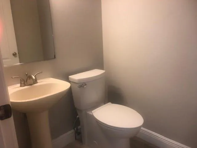 a white toilet sitting next to a white sink