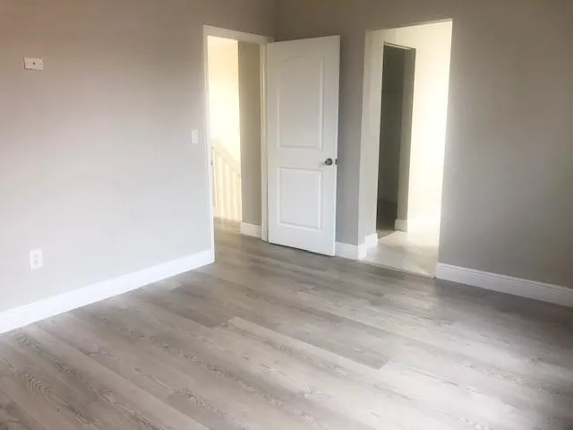 an empty room with wooden floor and closet