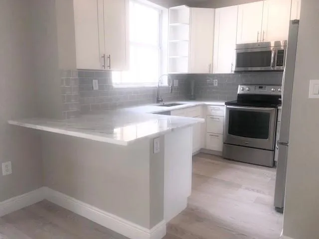 a kitchen with a sink appliances and cabinets