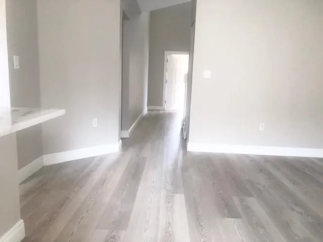 a view of a hallway with wooden floor
