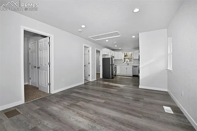 a view of empty room with wooden floor
