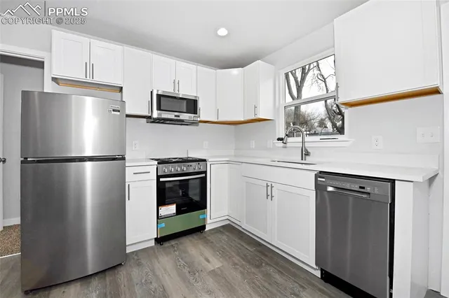 a kitchen with stainless steel appliances a refrigerator sink and microwave