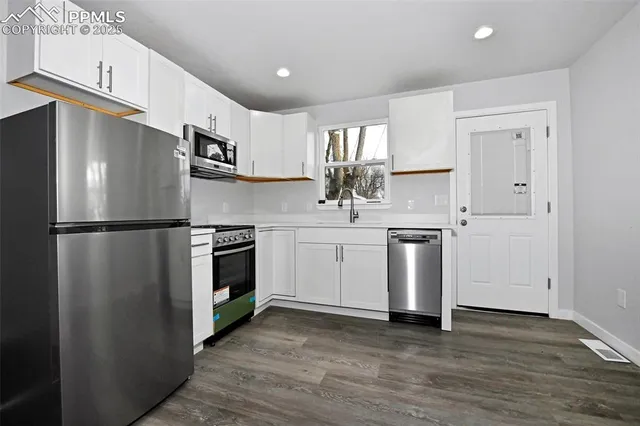 a kitchen with stainless steel appliances a refrigerator sink and cabinets