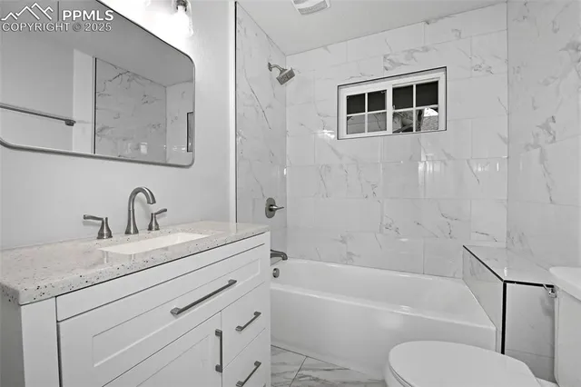 a bathroom with a granite countertop toilet sink and bathtub