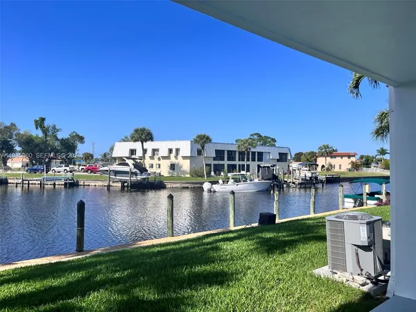 a view of a house with a yard next to a lake