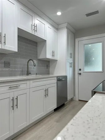 a kitchen with cabinets appliances and a sink
