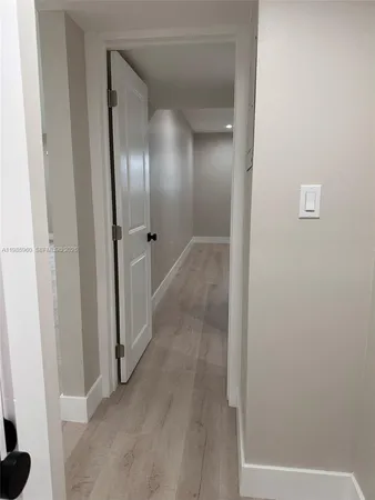 a view of a hallway with wooden floor