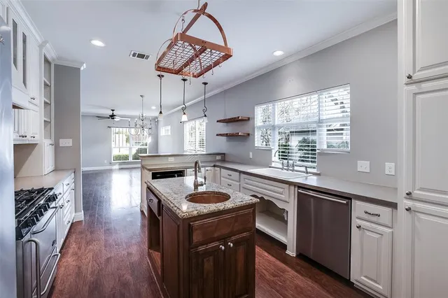 a kitchen with kitchen island a large counter top space a sink stainless steel appliances and cabinets
