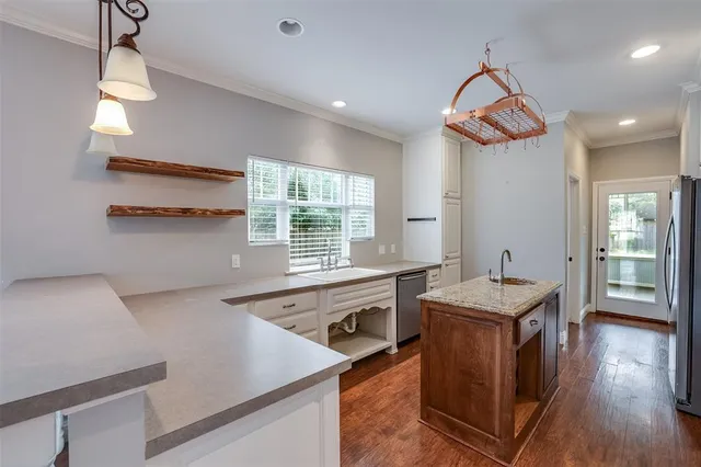 a kitchen that has a lot of cabinets and wooden floor