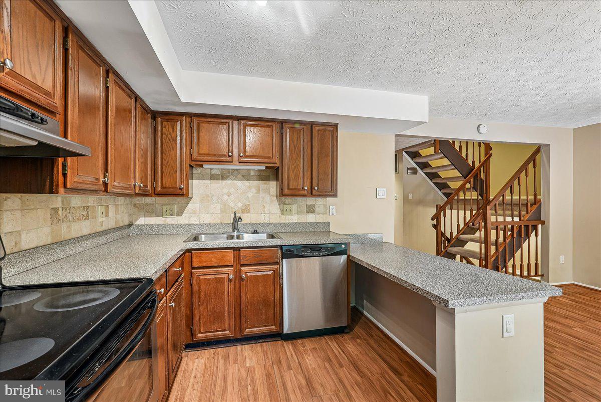2331 Middle Creek Lane Reston, VA 20191 - Photo 22 of 78 a kitchen with stainless steel appliances granite countertop a sink and wooden cabinets