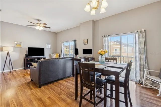 a living room with furniture a flat screen tv and kitchen view