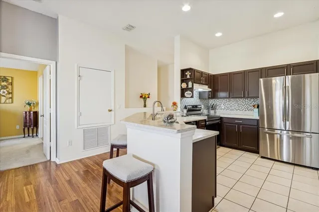 a kitchen with a sink a refrigerator and wooden floor
