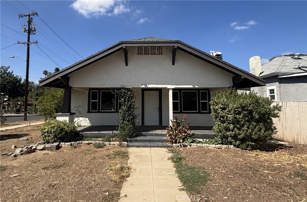 a front view of a house with a yard and potted plants