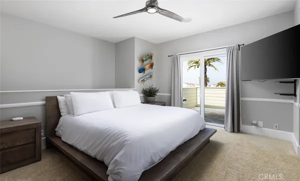 a bedroom with a bed and a flat tv screen on dresser