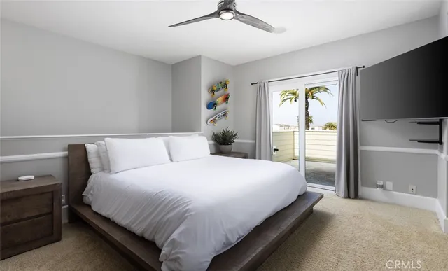 a bedroom with a bed and a flat tv screen on dresser