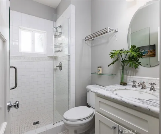 a bathroom with a granite countertop sink a toilet and shower