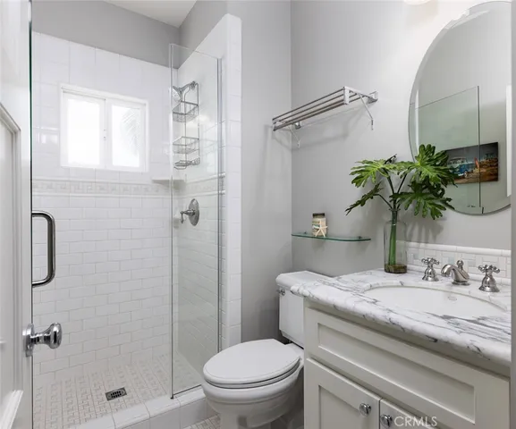 a bathroom with a granite countertop sink a toilet and shower