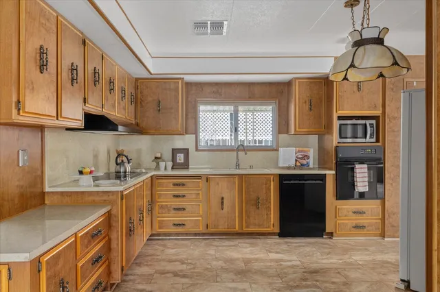 a kitchen with stainless steel appliances granite countertop a sink and a white cabinets