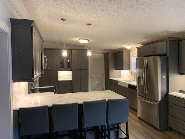 2132 Sagely Anderson Road Manchester, TN 37355 - Photo 4 of 14 a kitchen with stainless steel appliances kitchen island granite countertop a refrigerator a sink a stove a dining table and chairs