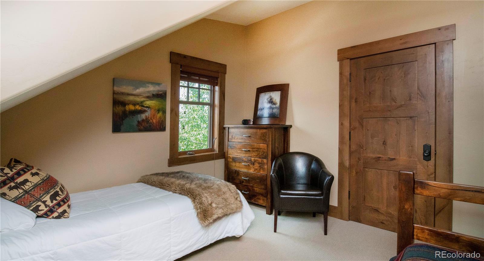 21 Meadow Trail Fraser, CO 80442 - Photo 32 of 36 a bedroom with a bed and a chair