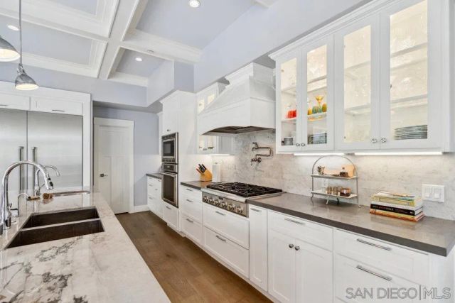 a kitchen with granite countertop a sink stainless steel appliances and cabinets