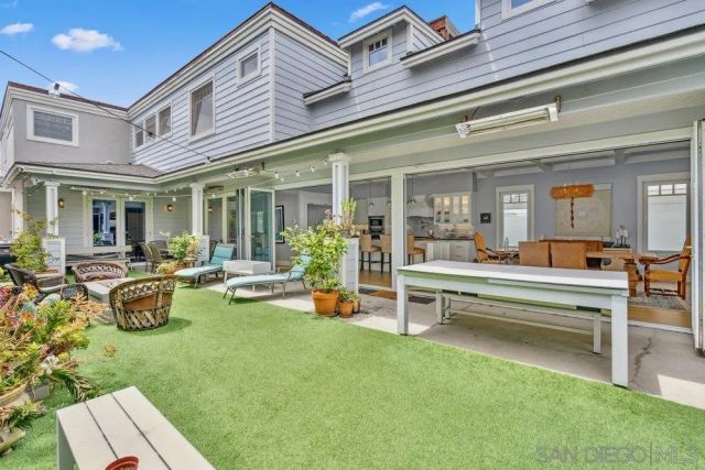 a view of a swimming pool with chairs and table in a patio