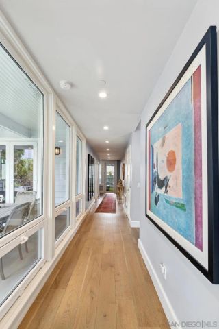 a view of a large living room with stainless steel appliances wooden floor and large windows