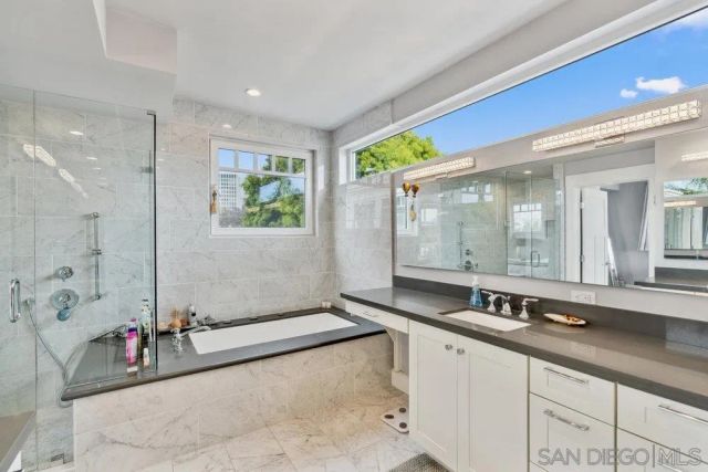 a bathroom with a tub sink and mirror