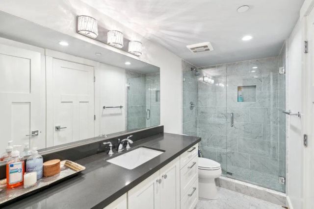 a bathroom with a double vanity sink toilet and shower