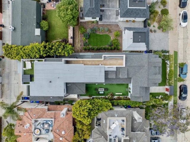 an aerial view of a house with a yard and a large tree