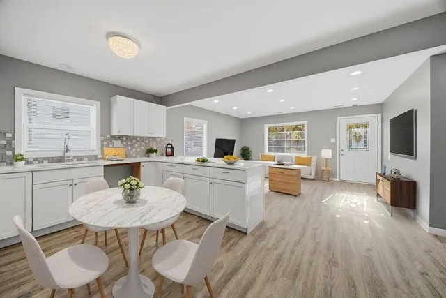 a kitchen with a sink white cabinets and stainless steel appliances