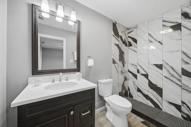 a bathroom with a sink toilet and a mirror