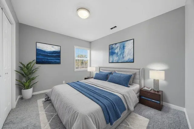 a bedroom with a bed and a painting on the wall