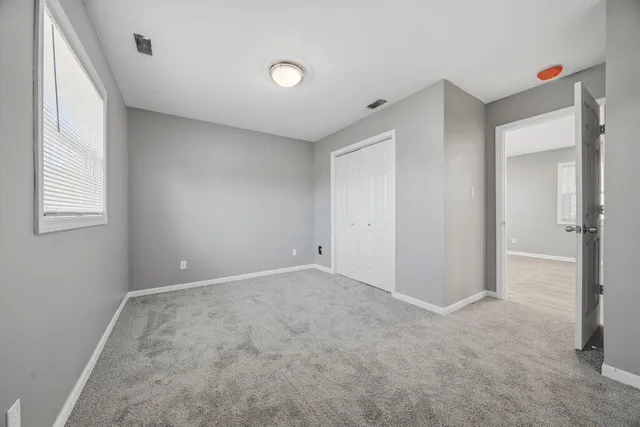an empty room with windows and closet